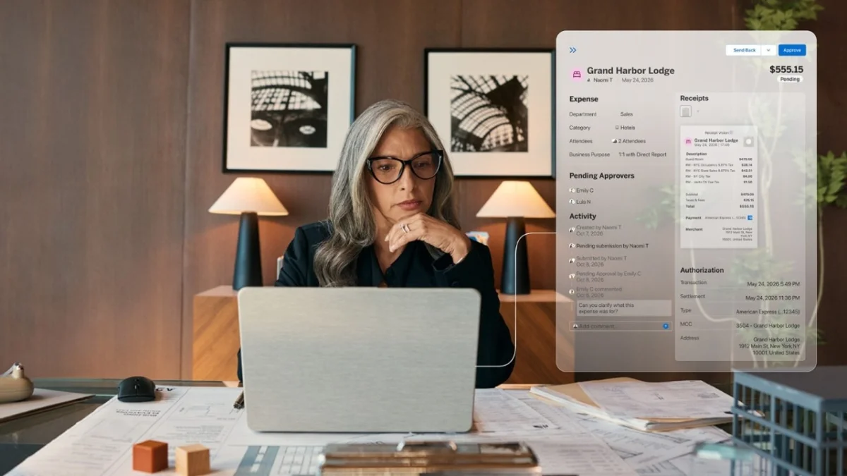 A finance manager reviews employee expenses on her laptop at her desk.